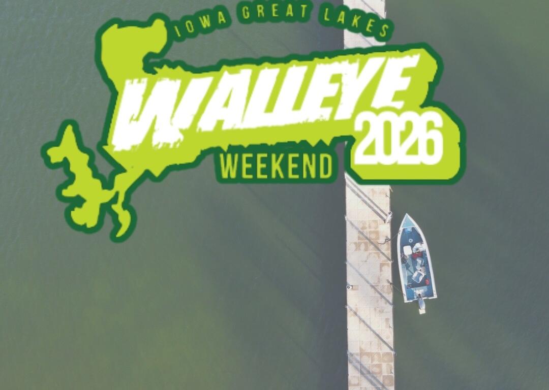 Aerial view of a pier extending into greenish water with a small boat nearby; overlaid is a bright neon-green logo reading 'WALLEYE WEEKEND 2026' for Iowa Great Lakes.