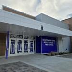 Front entrance of a modern school building with decorative glass doors featuring a large 'Titan Nation' graphic and a blue wall with the Graettinger–Terril Middle School & High School sign to the right.