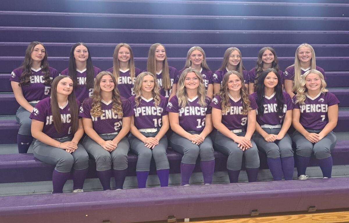 Group of girls in purple Spencer softball jerseys posing on gym bleachers.