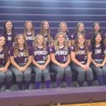 Group of girls in purple Spencer softball jerseys posing on gym bleachers.