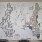 Large printed map showing wind energy site plan with dense zoning/legend details, laid out on a wall.