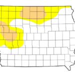 Map of Iowa counties with yellow and tan shaded regions in the northwest and north-central areas, likely indicating weather coverage or zones of interest.