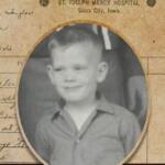 Vintage photograph of a smiling boy in a collared shirt, embedded in an old hospital record page.